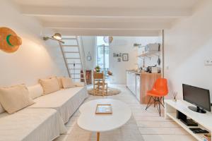 ein Wohnzimmer mit einem weißen Sofa und einem Tisch in der Unterkunft L'Octopus - Petit patio estival in Marseille