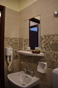 La salle de bains est pourvue d'un lavabo et d'un miroir. dans l'établissement Iliotropio Studios, à Loutra Edipsou