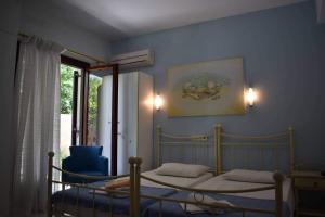 ein Schlafzimmer mit einem Bett und einer blauen Wand in der Unterkunft Iliotropio Studios in Loutra Edipsou