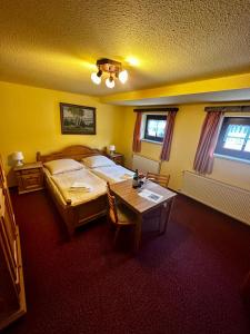 a bedroom with a bed and a table in it at Pension Zum Erzgebirge in Kurort Altenberg