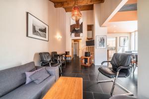 uma sala de estar com um sofá, cadeiras e uma mesa em Gîte Le Jorat - Appartement C em Bogève