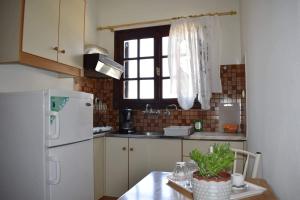 a kitchen with a table and a white refrigerator at Iliotropio Studios in Loutra Edipsou