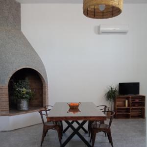 Vila Triana I Lea- Loft Rural في سانت كارليس دي لا رابيتا: غرفة طعام مع طاولة ومدفأة