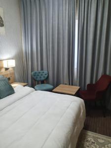 um quarto de hotel com uma cama grande e uma cadeira em Marbella Holiday Homes - Al Nahda 1BHK em Dubai