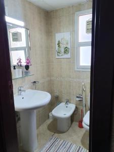 a bathroom with a sink and a toilet at Marbella Holiday Homes - Al Nahda 1BHK in Dubai