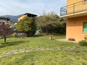 einen Hof neben einem Haus mit Balkon in der Unterkunft Casa vacanza Veronica con giardino in Verbania