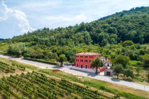 um edifício vermelho numa estrada ao lado de uma montanha em Rooms Casa Rossa in Motovun central Istria em Motovun