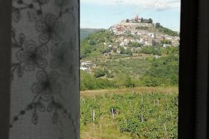 Blick auf eine Stadt auf einem Hügel aus einem Fenster in der Unterkunft Rooms Casa Rossa in Motovun central Istria in Motovun