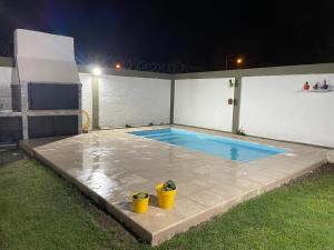 una piscina por la noche con dos cubos amarillos en La Piccolina en Tunuyán