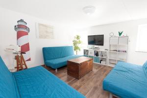 una sala de estar con 2 sillas azules y un faro en Sailing House Piran, en Piran