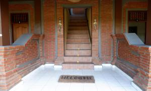 a brick building with a staircase and a door at Danasari Homestay in Ubud