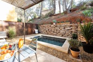 a swimming pool in a backyard with a stone wall at Mas du Clos , Tilleul in Roussillon