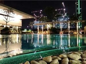 ein Schwimmbad in der Nacht mit einer Stadt im Hintergrund in der Unterkunft Apartment U Residence Tower 2 Karawaci, Tangerang Studio FULL FURNISHED SEWA in Klapadua