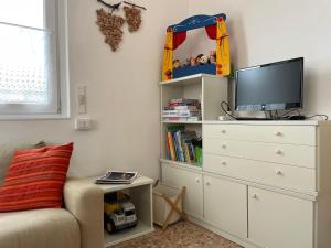 1 dormitorio con vestidor blanco y TV en Il nido del merlo Parcheggio e giardino en Verbania