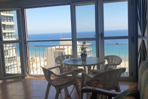 stolik i krzesła w pokoju z widokiem na ocean w obiekcie Beautiful apartment with view on the sea with aircond. w mieście Benidorm