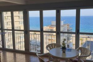 pokój ze stołem i widokiem na ocean w obiekcie Beautiful apartment with view on the sea with aircond. w mieście Benidorm