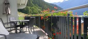 balcón con sillas, mesa y flores en Wittwerhus, en Gaschurn