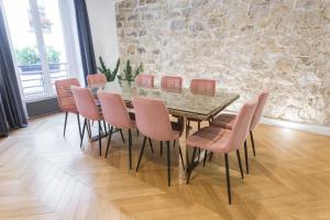 a dining room with a glass table and pink chairs at My Showroom in Paris