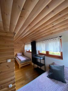 a bedroom with a large wooden ceiling and a bed at Istebna Pełna chata in Istebna