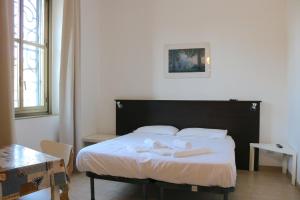 a bedroom with a bed with two towels on it at Le Residenze Della Poetessa in Corsico