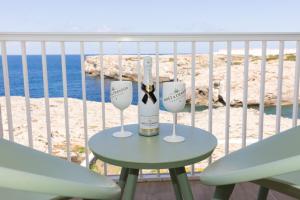 een tafel met twee glazen en een fles wijn bij VORAMAR in Cala en Forcat