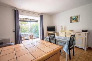 a dining room with a table with chairs and a window at Les Tulipes in Carqueiranne