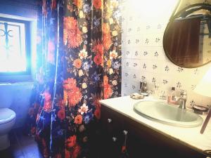 La salle de bains est pourvue d'un lavabo et d'un rideau de douche fleuri. dans l'établissement Palou 1900 Garraf, à Sant Pere de Ribes