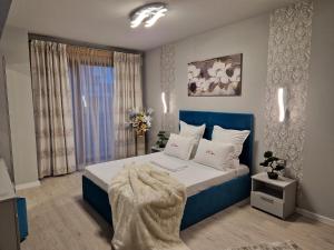 a bedroom with a blue and white bed and a window at Alecsa 2 Luxury Residence in Mamaia