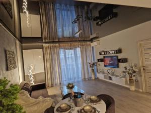 a living room with a table and a television at Alecsa 2 Luxury Residence in Mamaia
