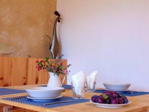 una mesa con platos de fruta y un jarrón de flores en Mirathe, en Baleyssagues