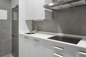 a kitchen with white cabinets and a sink at The Rentals Collection | Hondarribia in San Sebastián