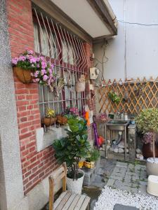 a patio with potted plants on a brick wall at 北斗合法古厝民宿 in Beidou
