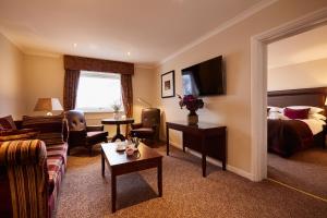 una camera d'albergo con divano e letto di Macdonald Highlands Hotel at Macdonald Aviemore Resort ad Aviemore