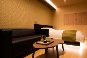 a living room with a couch and a bed at HOTEL ZEN-Adult Only in Hirosaki