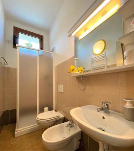 a bathroom with a toilet and a sink and a shower at Il nido del merlo Parcheggio e giardino in Verbania