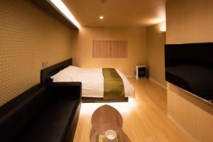 a small room with a bed and a tv at HOTEL ZEN-Adult Only in Hirosaki