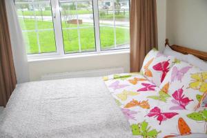 a bedroom with a bed with flowers on it at Cosy & convenient beach retreat in Tramore