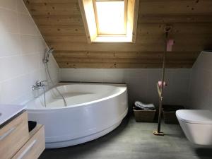 eine weiße Badewanne im Bad mit WC und Fenster in der Unterkunft Chambre d'hôtes Carélie et Laponie in Orbey