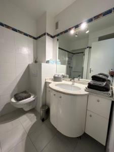 a bathroom with a sink and a toilet and a mirror at Studio Residence Du Casino in Menton