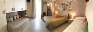 a bedroom with two beds and a couch at B&B CASA ELISABETTA in Ginosa