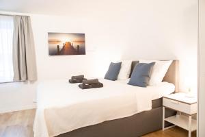 a bedroom with a white bed with two brown shoes on it at Gästezimmer ROSS in Hohenlinden