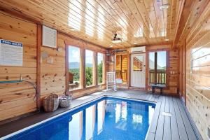 a swimming pool in a cabin with a wooden ceiling at Heated Pool Hot Tub Game Room Mountain Views in Sevierville