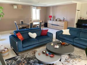 una sala de estar con 2 sofás azules y una mesa. en Villa Rochefort-du-Gard proche Avignon, en Rochefort-du-Gard