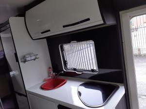 a small kitchen with a sink and a microwave at Easicampers Edinburgh in Broxburn