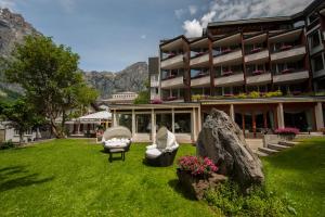 a hotel with a green lawn in front of a building at Hotel Quellenhof Leukerbad in Leukerbad