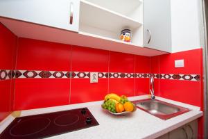 una cucina rossa con un cesto di frutta su un bancone di ACIKA apartments a Rafailovici