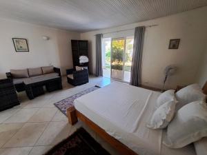 ein Schlafzimmer mit einem Bett und ein Wohnzimmer in der Unterkunft Aux 2 Métis in Toliara