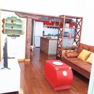 a living room with a couch and a red stool at Atico con encanto en el mismo centro de la ciudad in Santander