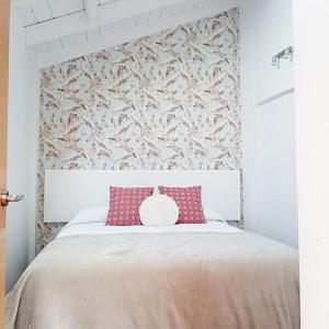 a bedroom with a large white bed with red pillows at Atico con encanto en el mismo centro de la ciudad in Santander
