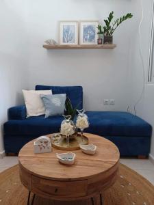 a living room with a blue couch and a wooden table at Holiday House near Beach in Skala Fourkas